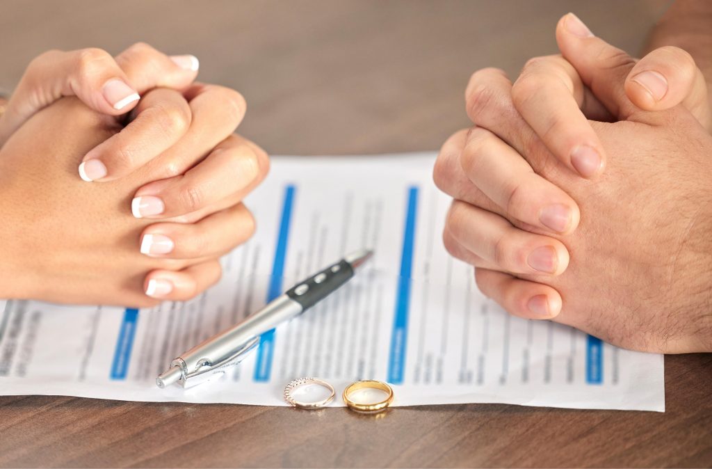 Contrato hipotecario con dos firmas junto a convenio regulador de divorcio, ilustrando que el banco no queda vinculado por el reparto de deudas en el divorcio